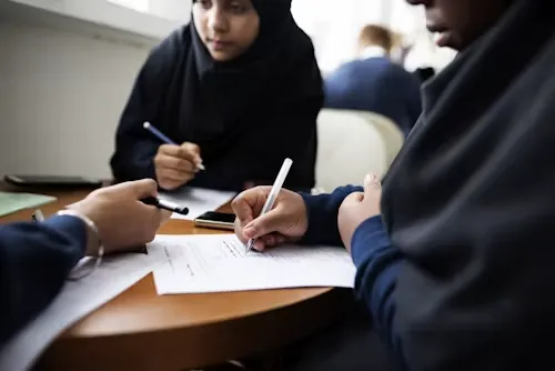 A university student in Dubai checking referencing style requirements for a coursework report